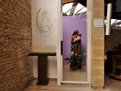 Scopriamo la statua della "Madonna della Tenerezza" nascosta oltre una delle due quinte, in un vano a cui si accede attraverso una piccola porta a vetri, fiancheggiata da un gruppo di candele votive